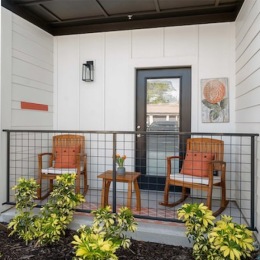 a patio with chairs and plants