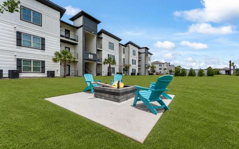 a lawn with chairs and a fountain